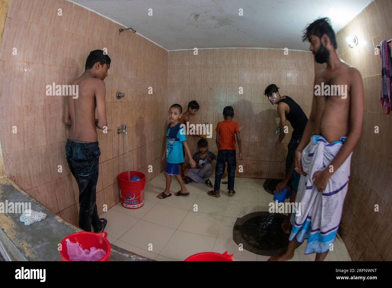 Bewohner des gestrandeten Pakistanis Relief Camps in Dhaka Mohammadpur, allgemein bekannt als „Genfer Camp“, baden in einem gemeinsamen Badezimmer. Die 'Stran Stockfoto