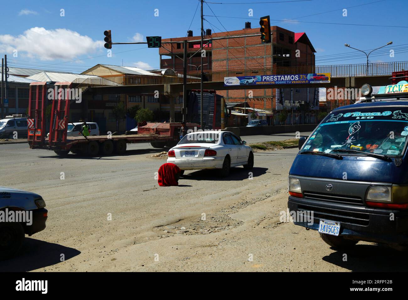 Die Hyundai wurde zerstört und das Rad war mit einer roten Decke bedeckt, die als Warndreieck in der Mitte der Hauptstraße durch Senkata, El Alto, Bolivien verwendet wurde Stockfoto