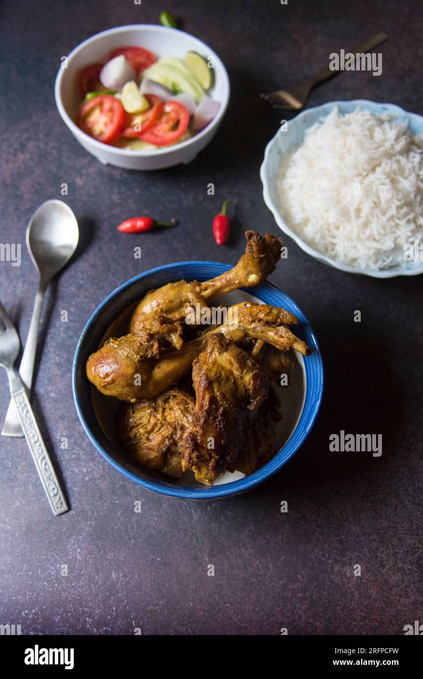 Fertiggerichte für indische nicht-vegetarische Gerichte, Hühnchen Masala, Reis und Salat. Stockfoto
