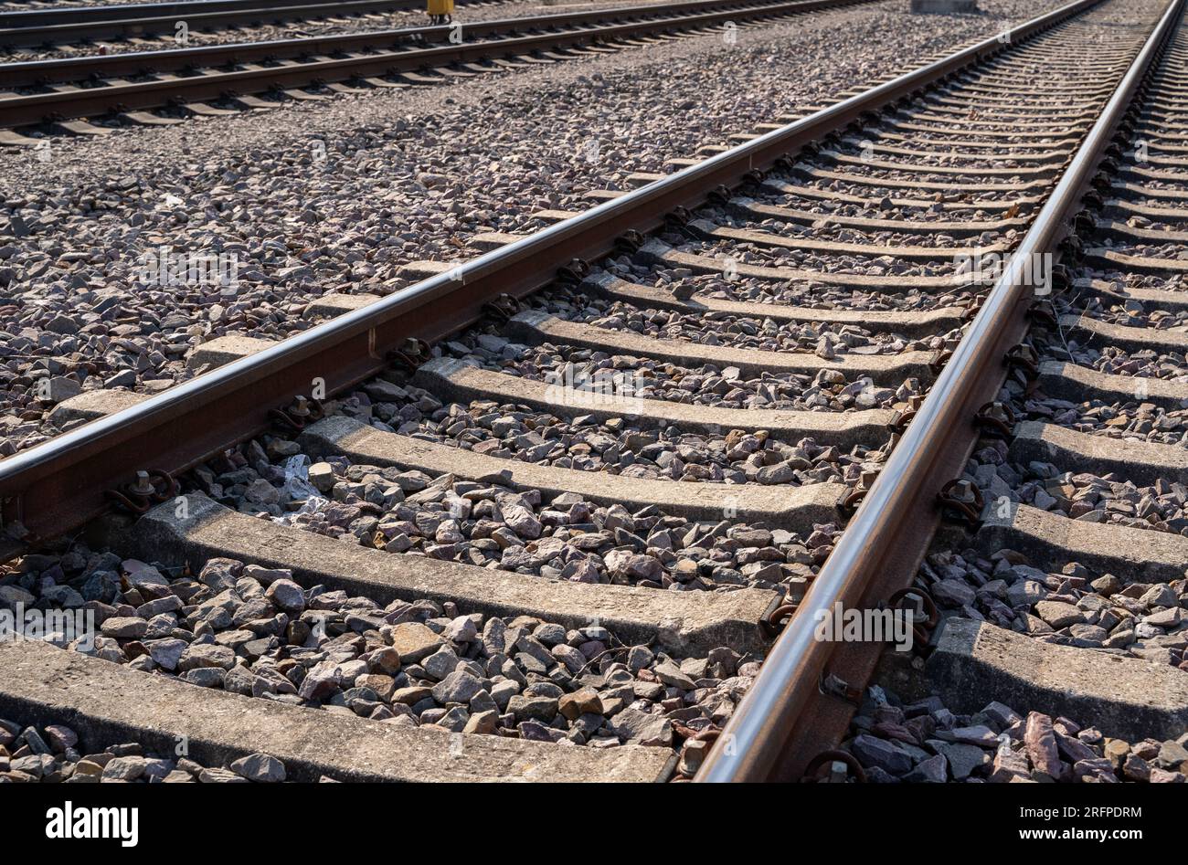 Nahaufnahme von rostigen Eisenbahnschienen mit Schottersteinen Stockfoto