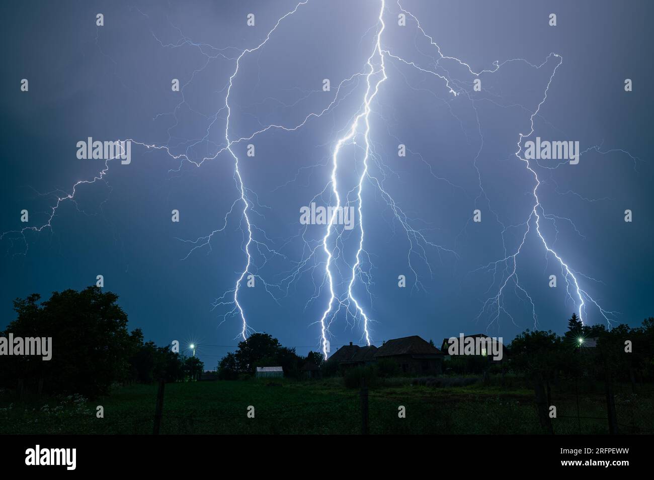 Mehrere verzweigte Blitze treffen in einer stürmischen Nacht auf die Erde. Stockfoto