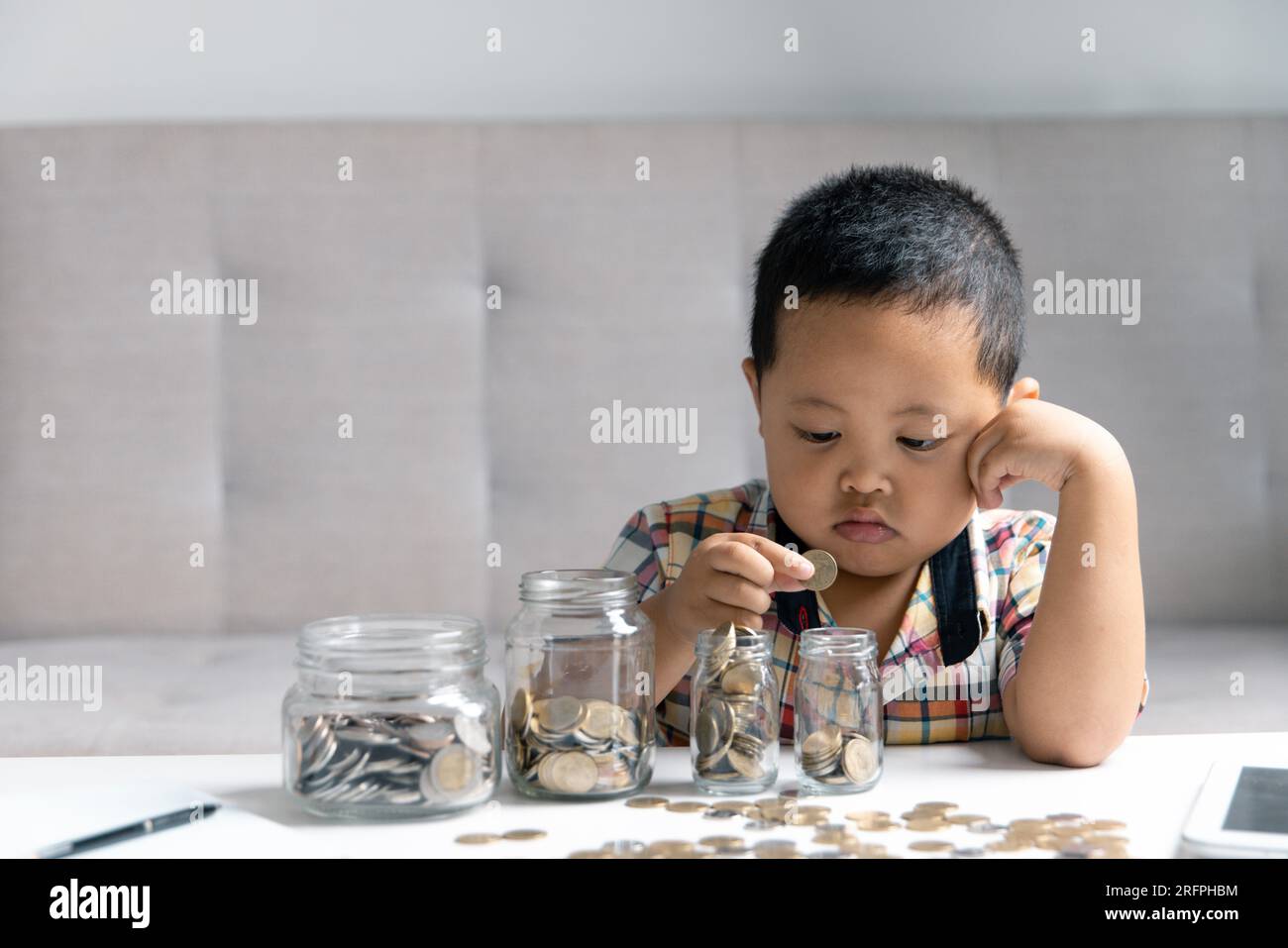 Vorschulkinder lernen, um das persönliche Budget zu berechnen, Finanzen zu verwalten, Investitionen zu spielen, Buchhaltung. Fokussiertes Schulkind, das beim Kauf Geld spart, Stockfoto