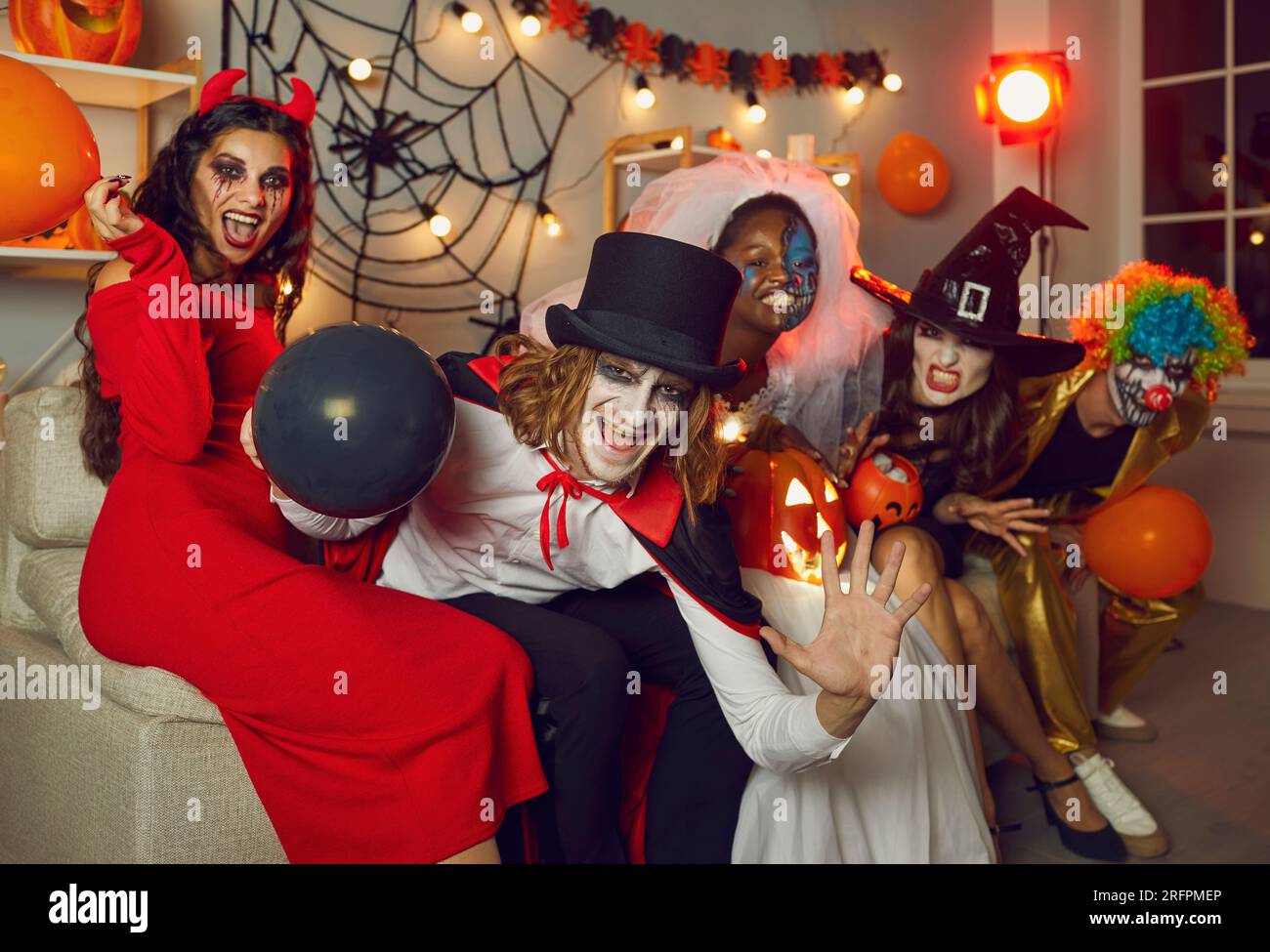 Glückliche Erwachsene Freunde in gruseligen Kostümen, die Spaß auf der Halloween-Party haben Stockfoto