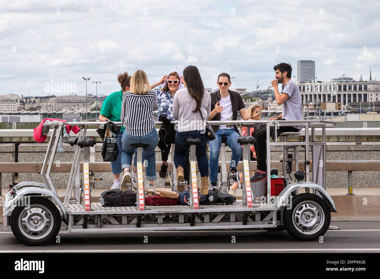 Eine Junggesellenparty auf einem Aparty Bike, Bier Bike oder Bar Bike, mit dem Fahrrad den Trolley im Zentrum von London, England, verlegen Stockfoto