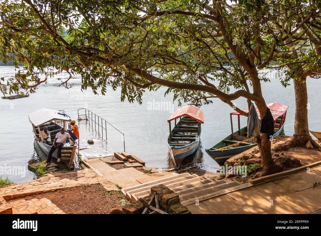 Drei Flussboote, die am Ufer vor Anker liegen, erwarten Touristen für einen Ausflug auf dem Nil in Jinja, Uganda. Stockfoto