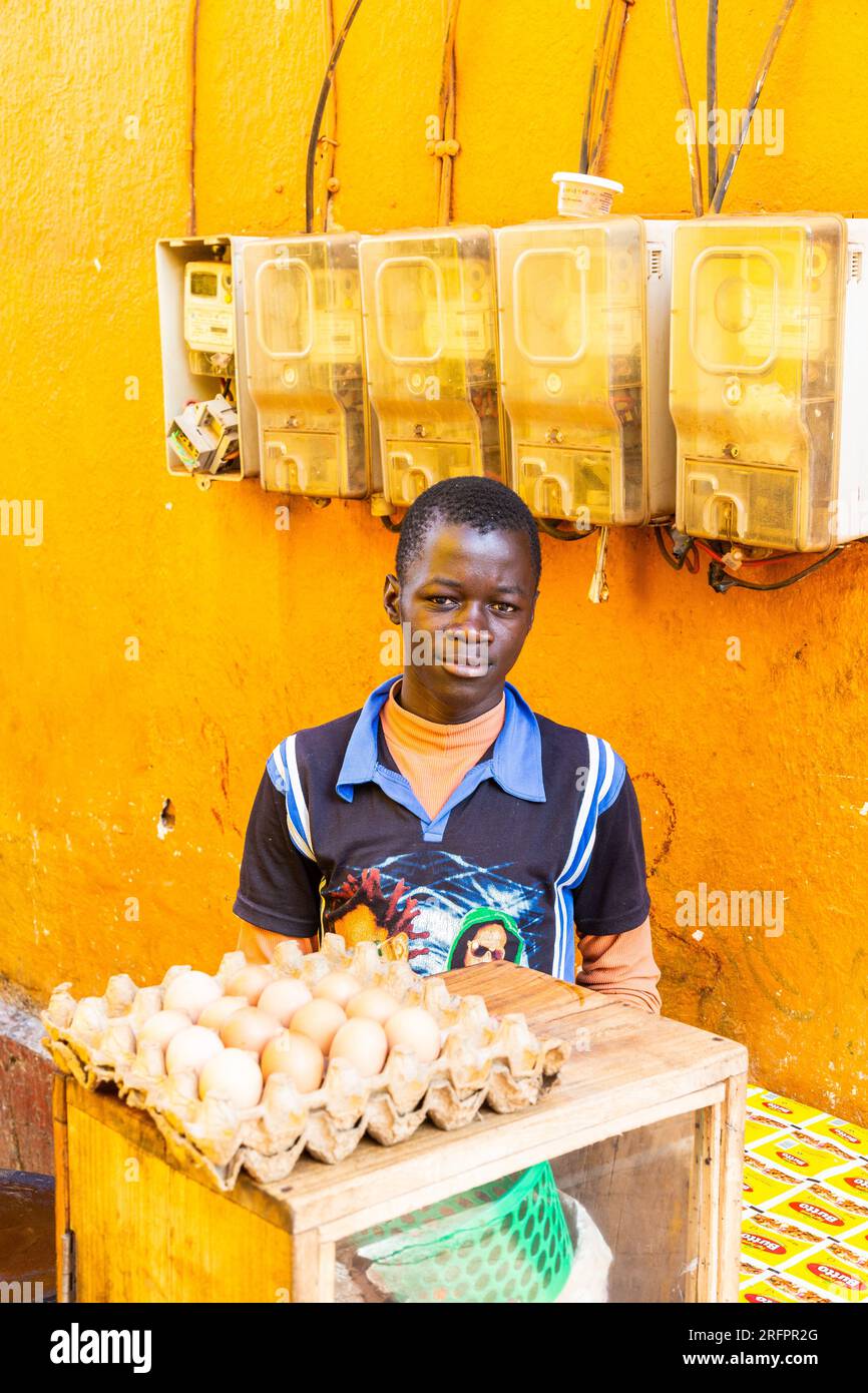 Junge Eierverkäufer auf dem Markt von Jinja, Uganda. Gelbe Umgebung. Stockfoto