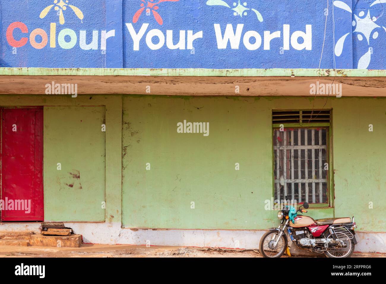Bringen Sie Farbe in Ihre Welt. Grüne Wand und Motorrad. Jinja, Uganda. Stockfoto