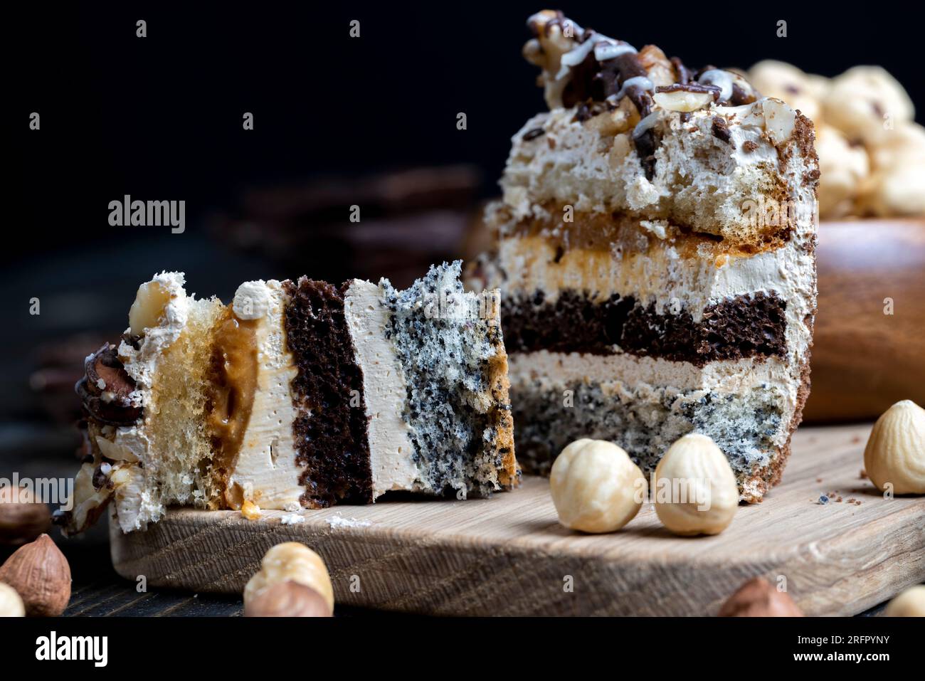 Mehrschichtiger Kuchen mit verschiedenen Schichten, Karamell, Mohn und Cremeschichten Kuchen zum Dessert mit Nüssen Stockfoto