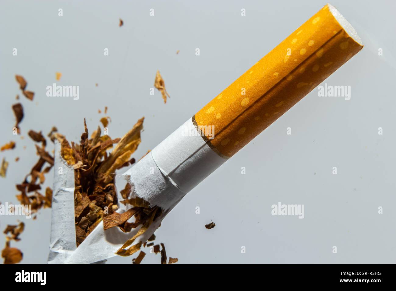 Gebrochene Zigarettenfliege in der Luft auf einem hellen Hintergrund. Konzeption der Bekämpfung des Rauchens. Stockfoto