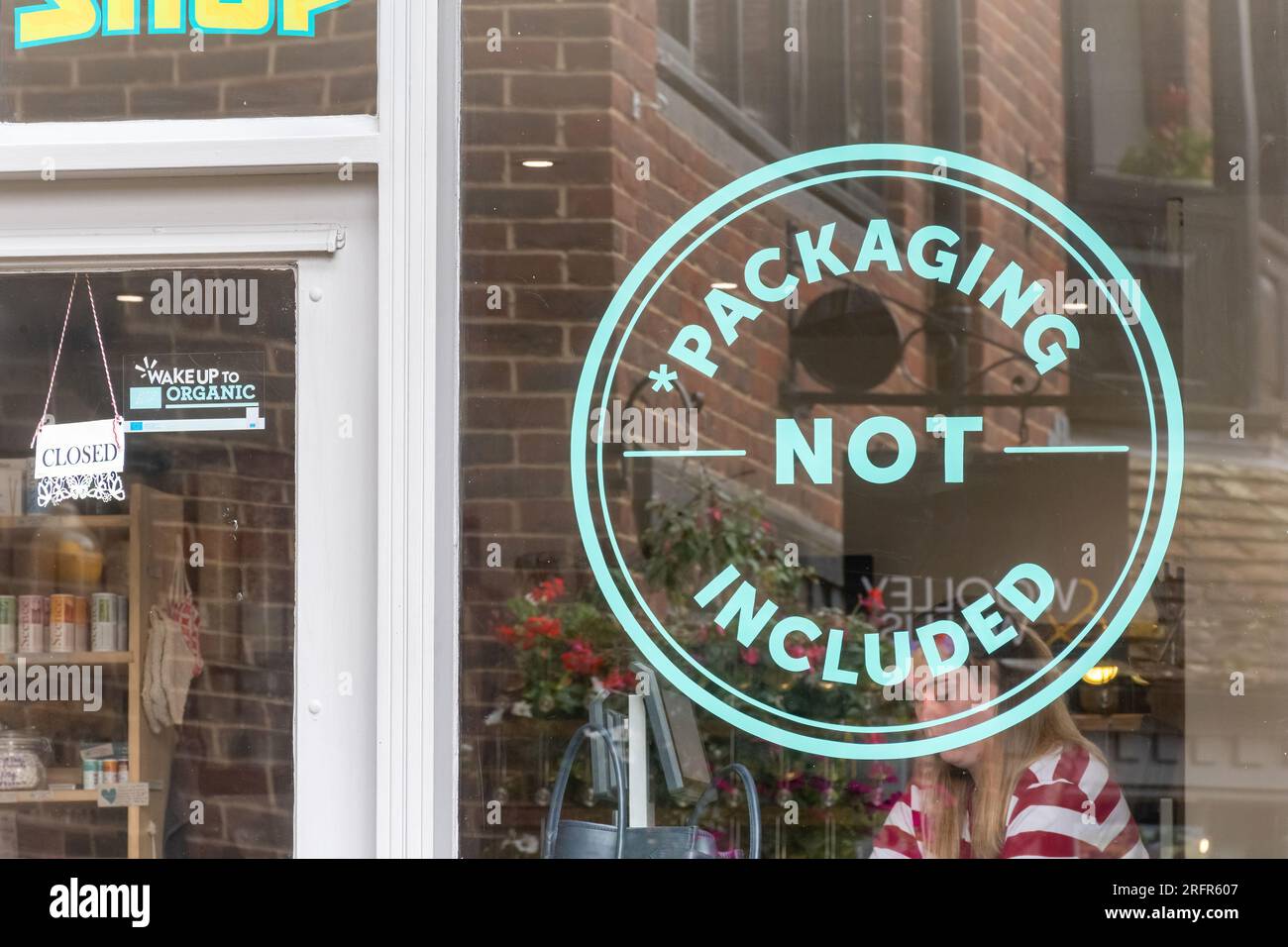 Schild „Verpackung nicht enthalten“ im Fenster „Zero Waste Shop“, England, Großbritannien. Reduzierung von Einwegkunststoffen, Nachhaltigkeit Stockfoto
