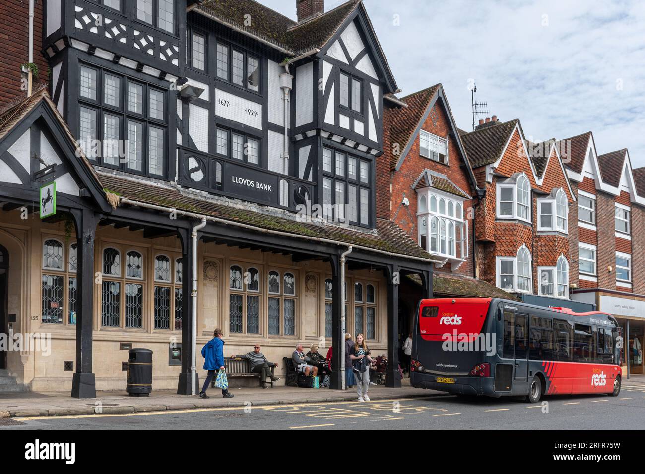 Leute an der Bushaltestelle vor der Lloyds Bank im Stadtzentrum von Marlborough mit einem Salisbury Reds Bus, der an der High Street, Wiltshire, England, hält Stockfoto