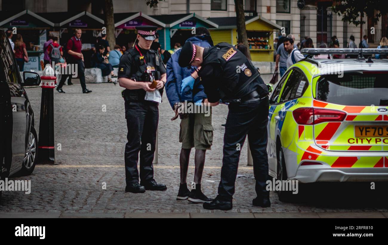 Ein Mann ist gefesselt und wird außerhalb von St. durchsucht Pauls Kathedrale in London. Stockfoto