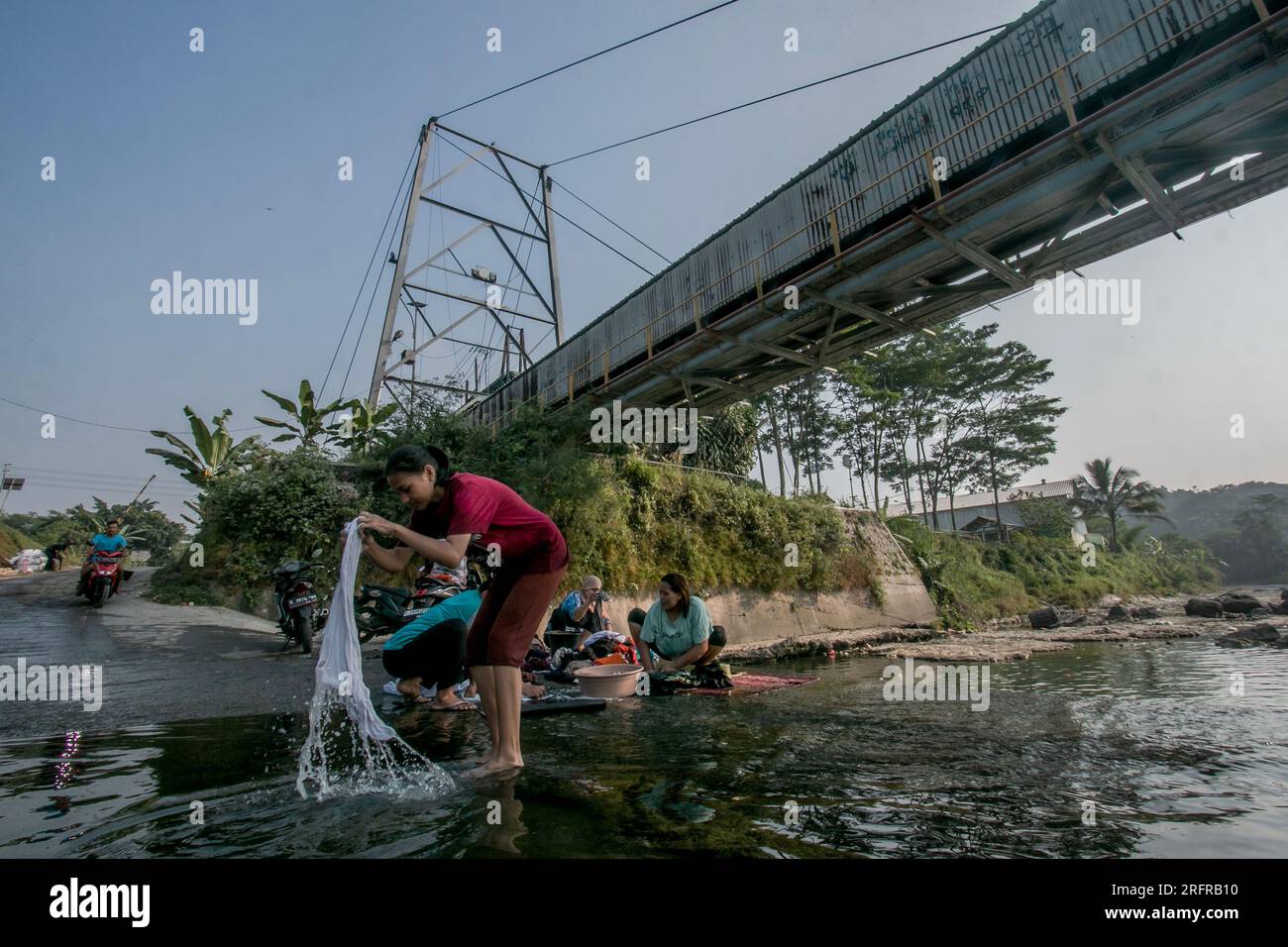 Bogor, Indonesien - 05. August 2023: Aktivitäten von Einwohnern in Bogor, Wäsche waschen und Motorräder im Fluss Stockfoto