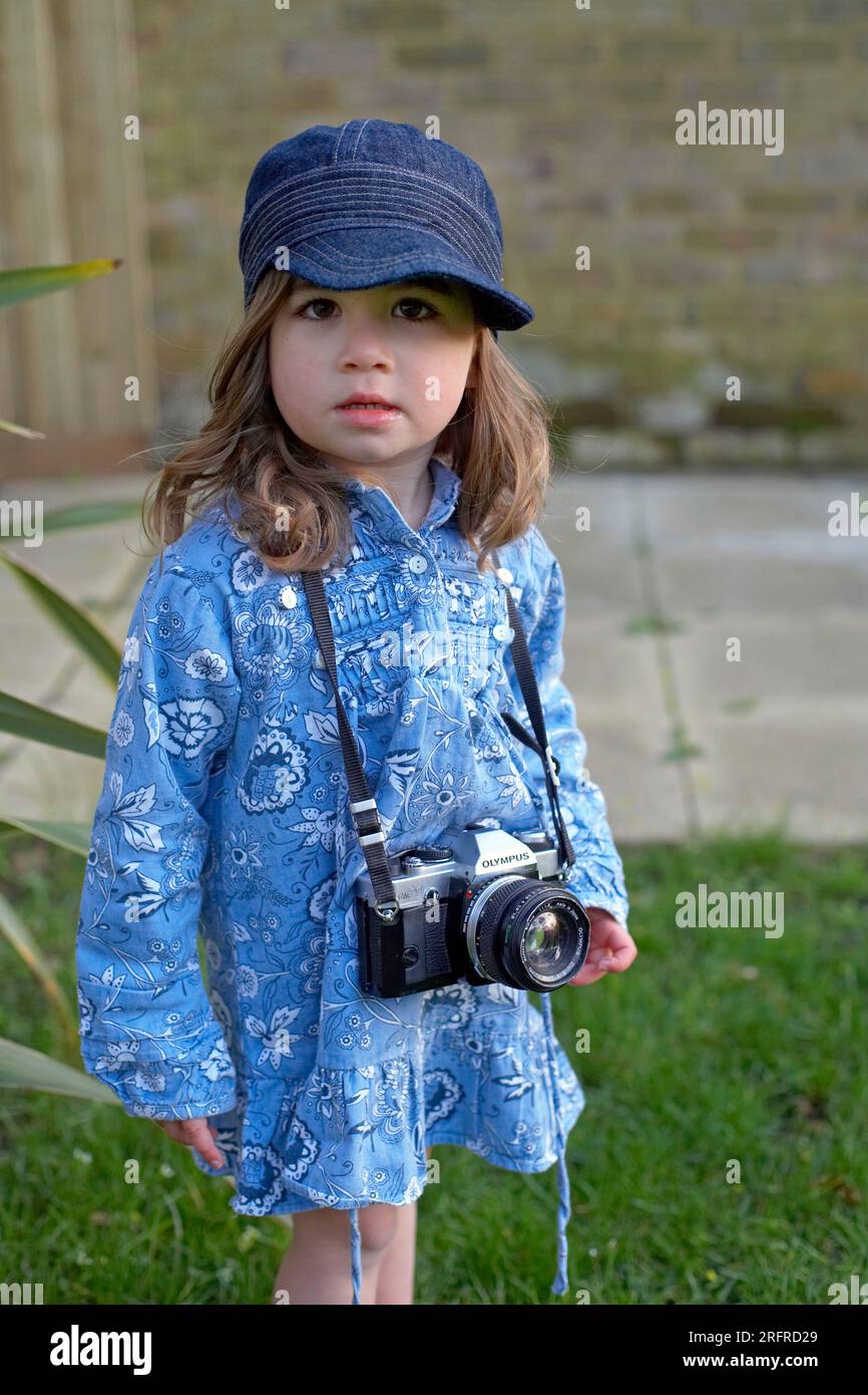Kleines Kind mit einer Retro-Kamera um den Hals draußen Stockfoto
