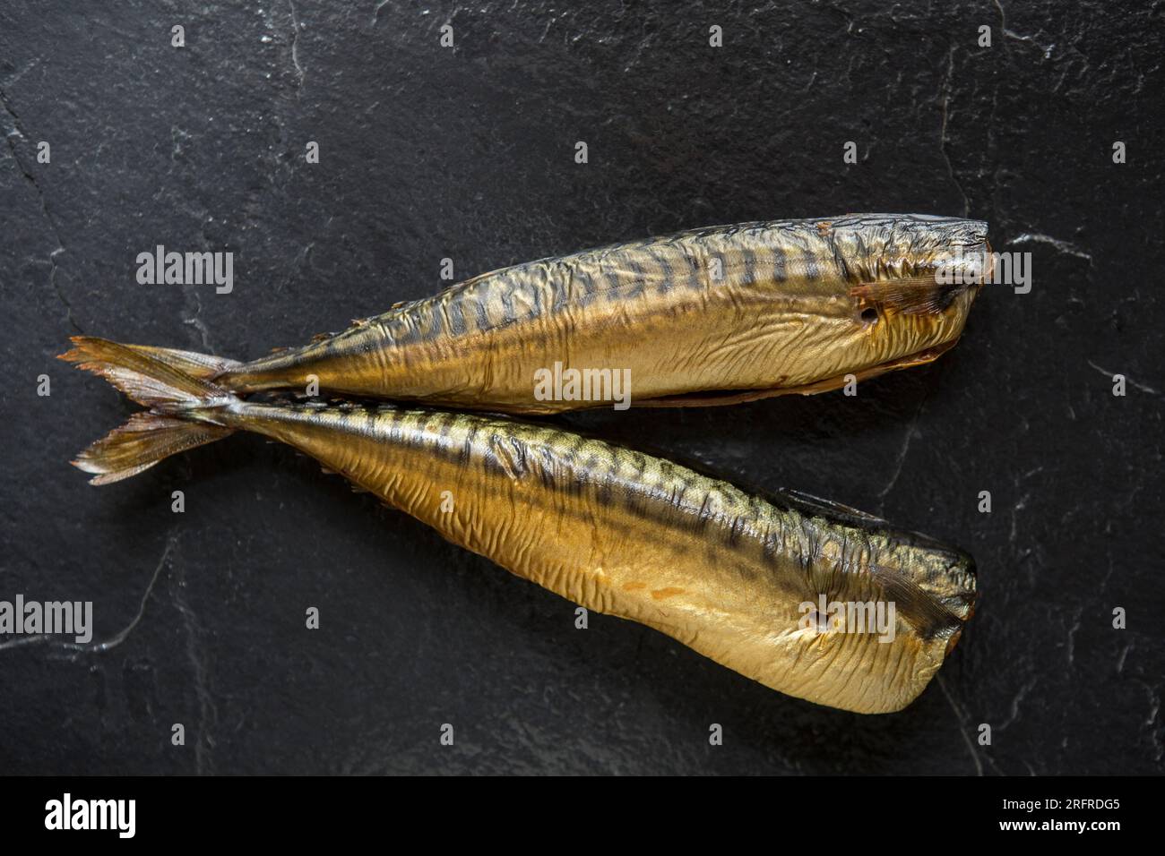 Heiße geräucherte Makrele, Scomber scombrus, auf dunklem Schieferhintergrund. England GB Stockfoto