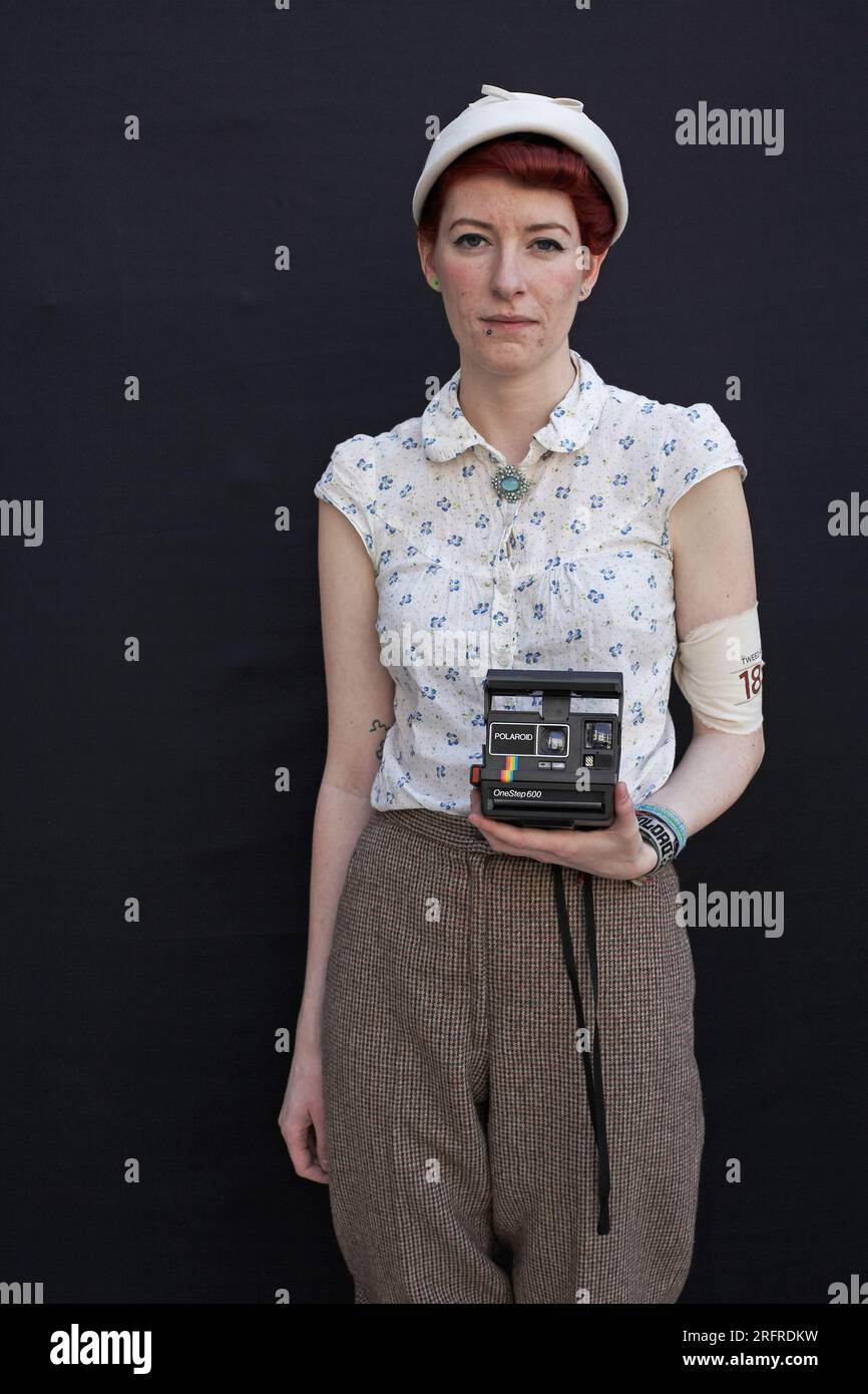 Die Frau hält eine polaroid-Kamera in der Hand Stockfoto