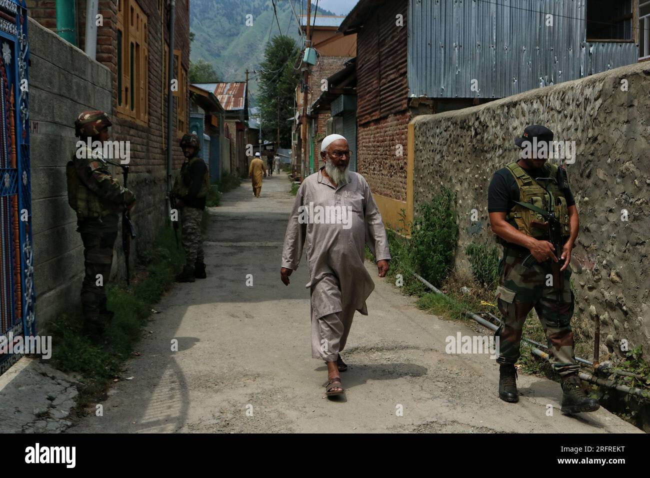 Bandipora Kaschmir, Indien. 05. Aug. 2023. Ein Mann geht an indischen Soldaten vorbei und steht vor dem Haus ihres Kollegen Waseem Sarvar Bhat in Bandipora, nördlich von Srinagar, Wache. Bhat gehörte zu drei Soldaten der indischen Armee, die am 04. August 2023 bei einer Begegnung mit militanten Kämpfern im Bezirk Kulgam im Süden Kaschmirs getötet wurden. Am 05. August 2023 in Bandipora Kaschmir, Indien. (Kreditbild: © Firdous Nazir/Eyepix via ZUMA Press Wire) NUR REDAKTIONELLE VERWENDUNG! Nicht für den kommerziellen GEBRAUCH! Stockfoto