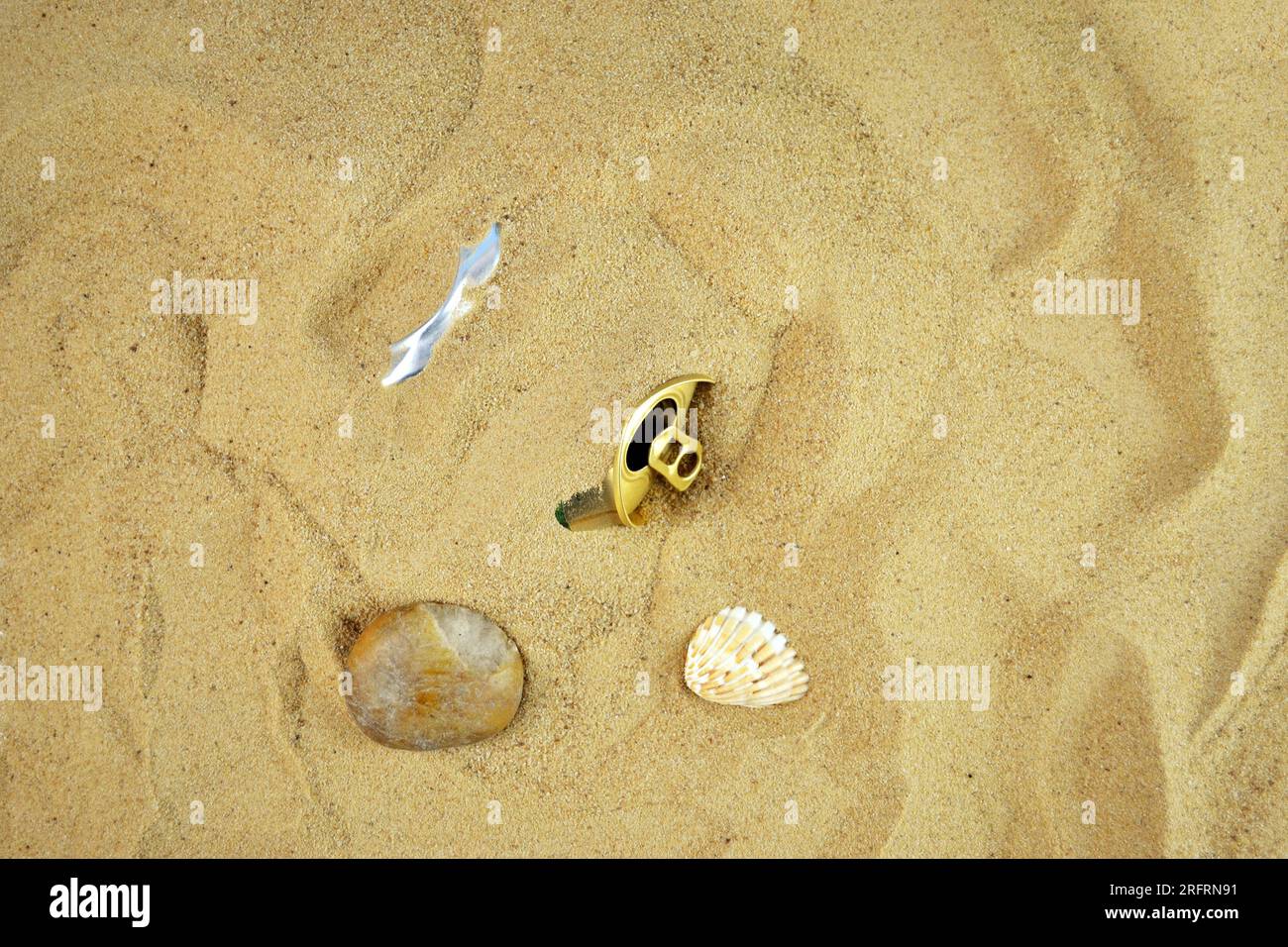 Eine leere Dose eines Getränks wurde von Besuchern am Strand zurückgelassen und mit Sand begraben Stockfoto