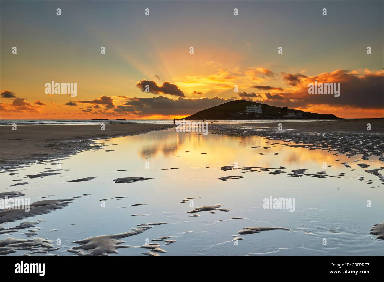 Ein Winteruntergang über einem Strand und einer Insel bei Ebbe; von Bigbury aus gesehen, mit Blick auf Burgh Island, Devon, Großbritannien. Stockfoto