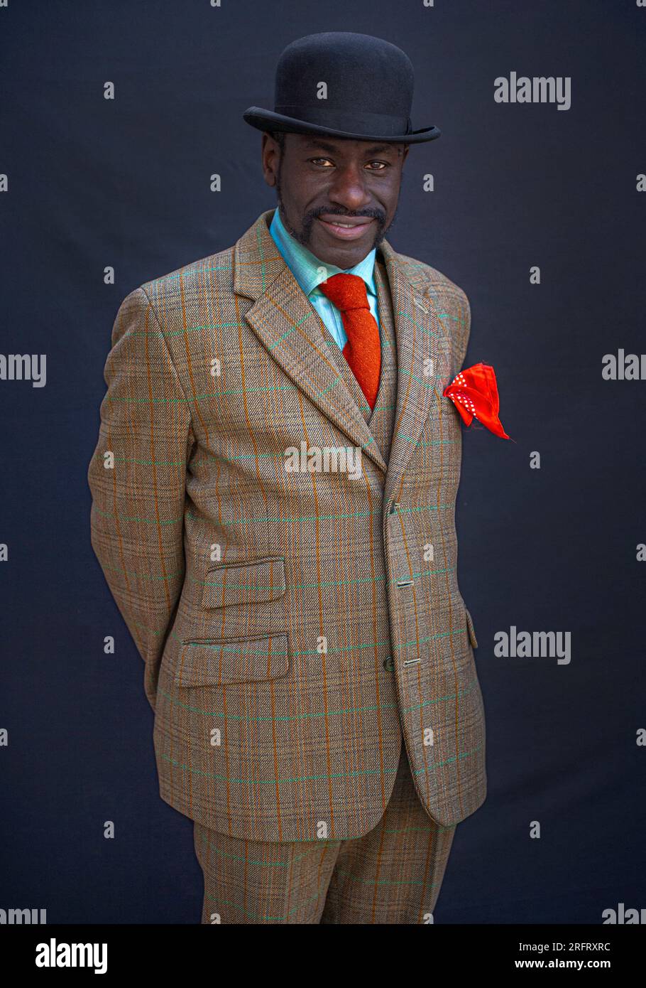 Ein stylischer afrikanischer Mann trägt Anzüge und eine Bowler-Mütze Stockfoto