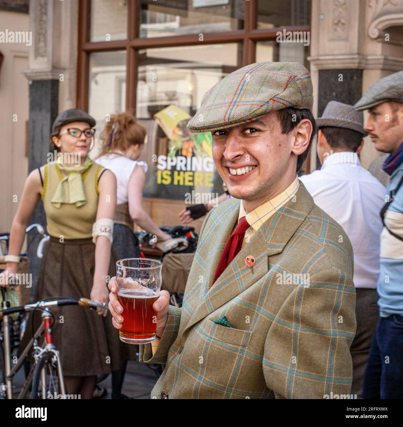 Mann mit traditionellem Anzug und Mütze trinkt Bier vor dem Pub in London, Großbritannien. Stockfoto