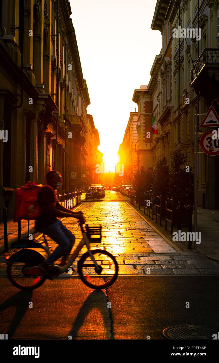 Ein Blick auf Turin bei Sonnenuntergang mit einem Reiter, der jemandem das Abendessen bringt Stockfoto