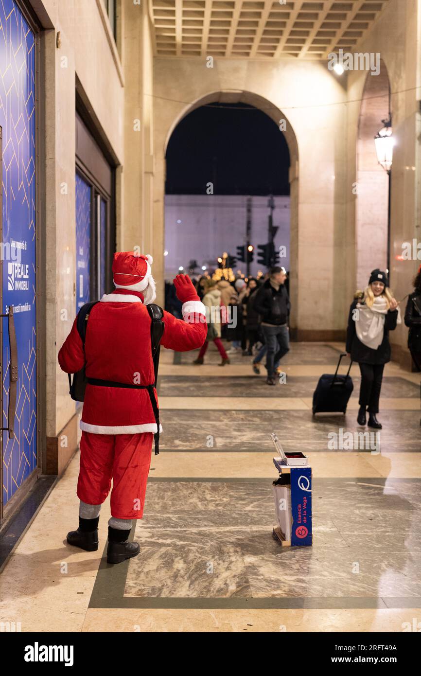Ein als Weihnachtsmann verkleideter Bettler begrüßt und unterhält Passanten in der Hoffnung, ein kleines Weihnachtsangebot zu erhalten. Stockfoto