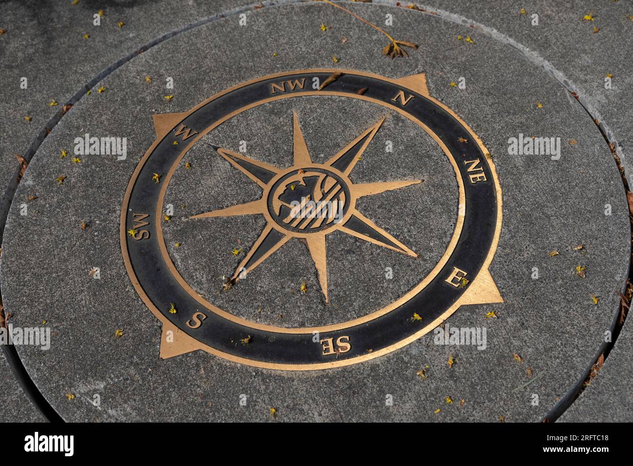 Ein Schachtdeckel, der vor Ort als Lukenabdeckung bekannt ist, ist mit einer Kompassrose und dem Profil von Chief Seattle in Seattles wohlhabendem Alki-Viertel verziert Stockfoto