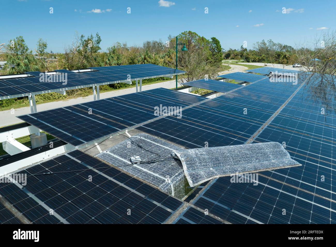 Zerstört durch Hurrikan-Windenergie, Photovoltaik-Solarpaneele auf dem Carport-Dach zur Erzeugung von ökologischem Strom zum Aufladen von Elektrofahrzeugen Stockfoto