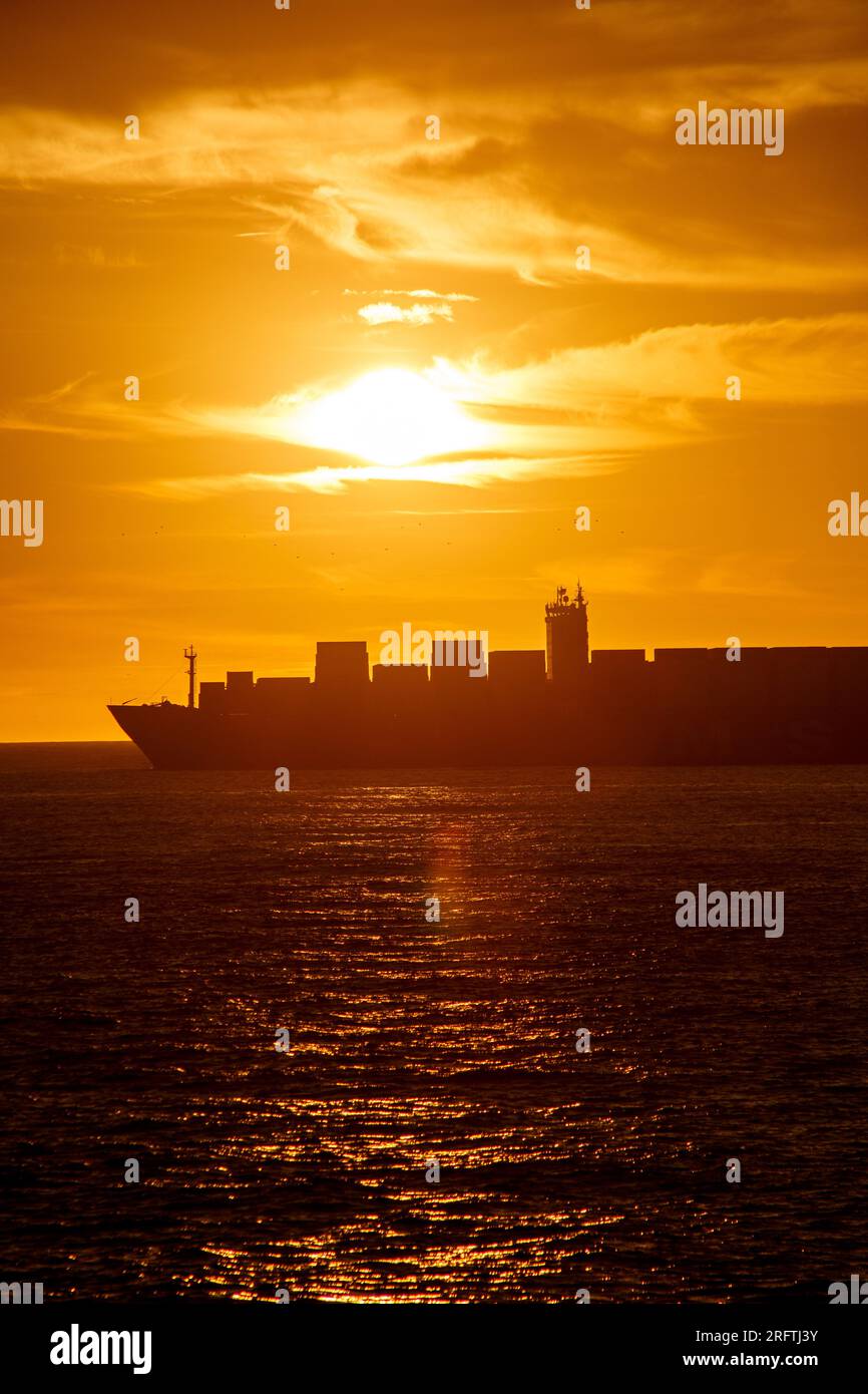 Silhouette eines Frachtschiffs bei Sonnenaufgang am Strand der copacabana in rio de Janeiro, brasilien. Stockfoto