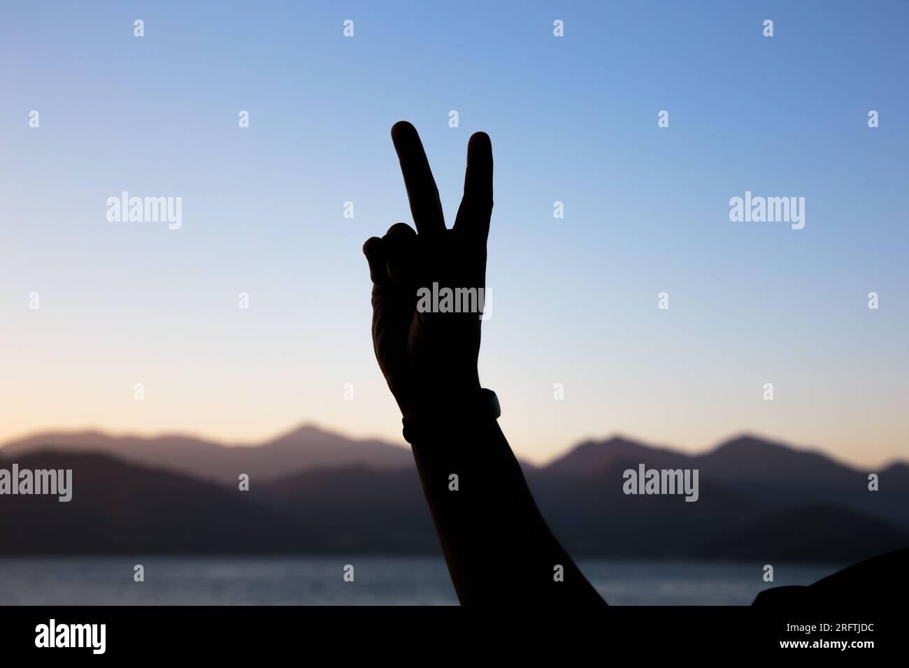 Silhouette der Hände in Form der Nummer zwei mit einem wunderschönen farbenfrohen Nachmittagshimmel in Rio de Janeiro, brasilien. Stockfoto