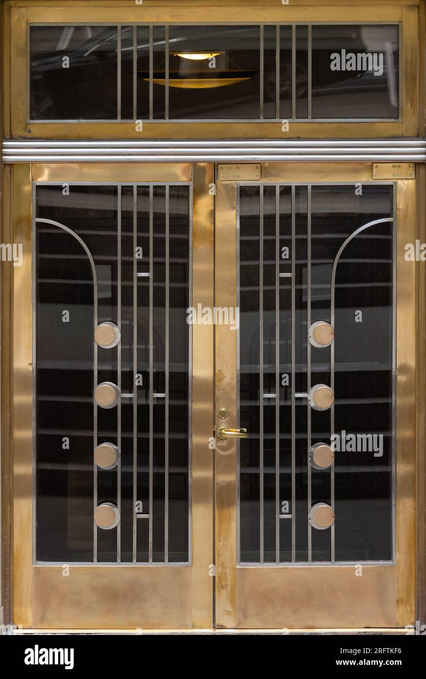 Eingangstüren im Art déco-Stil mit geometrischem Design in Chrom und Messingmetall Stockfoto