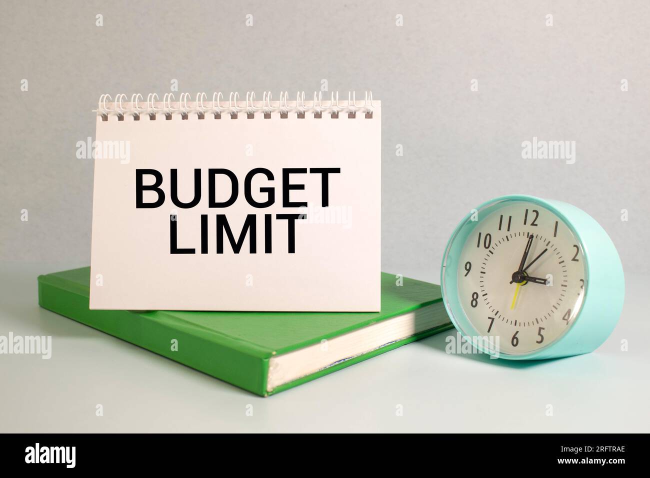 Text für BUDGETBESCHRÄNKUNGEN auf der Seite des Umschlags. Auf dem Arbeitstisch. Draufsicht, flach liegend. Stockfoto