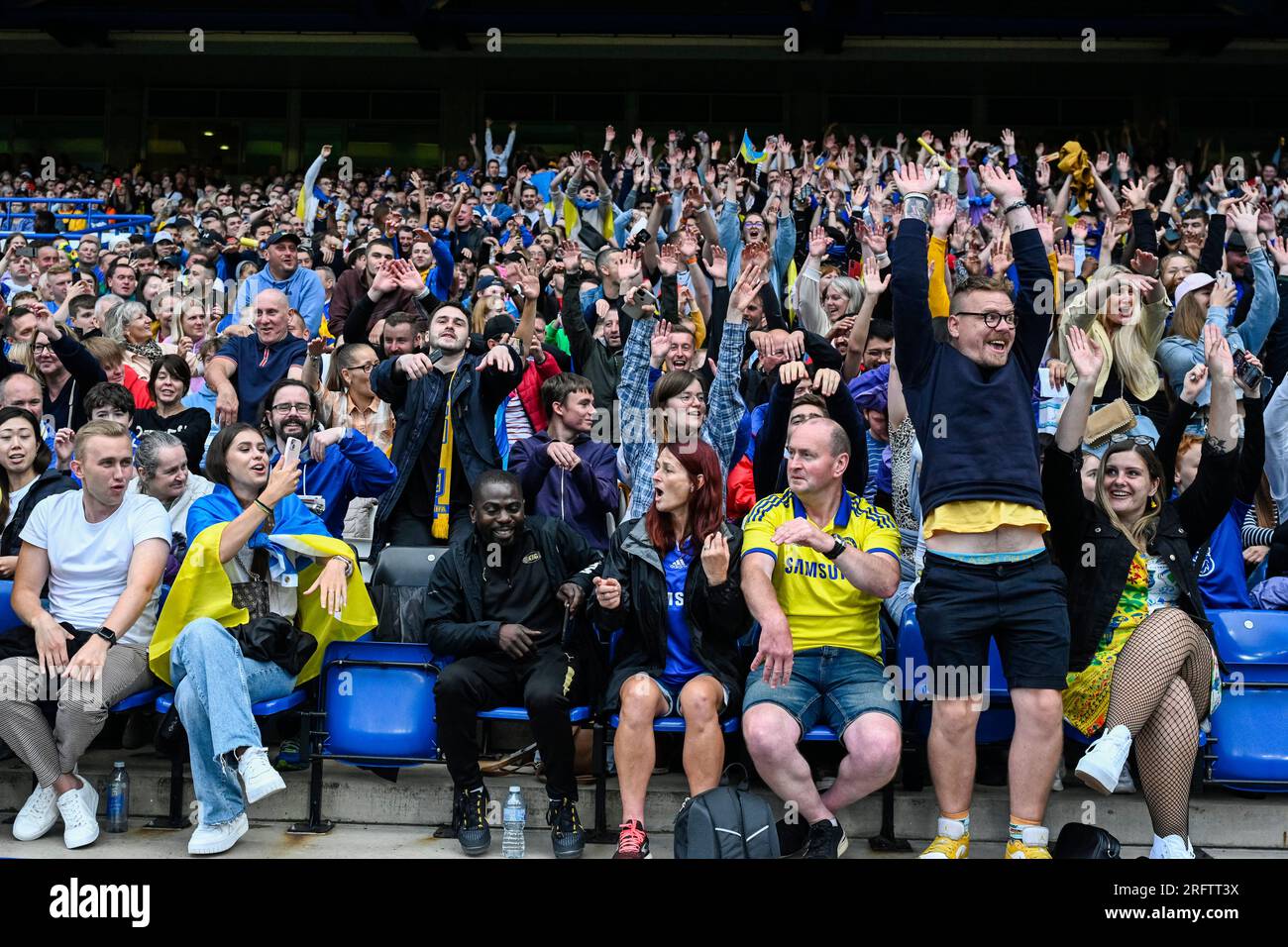 London, Großbritannien. 5. August 2023. Die Zuschauer spielen während des Wohltätigkeitsspiels Game4Ukraine auf der Stamford Bridge, der Heimat des Chelsea FC, zwischen dem ehemaligen Chelsea-Stürmer Andriy Shevchenko's Team Shevchenko (blau) und dem aktuellen Arsenal-Full-Back-Team Zinchenko von Oleksandr Zinchenko (gelb) eine mexikanische Welle. Mit den bereitgestellten Mitteln wird die United24 eingeleitete Initiative des ukrainischen Präsidenten Volodymyr Zelensky unterstützt, Schulen in der gesamten Ukraine wieder aufzubauen, die durch die russische Invasion beschädigt wurden. Kredit: Stephen Chung / Alamy Live News Stockfoto