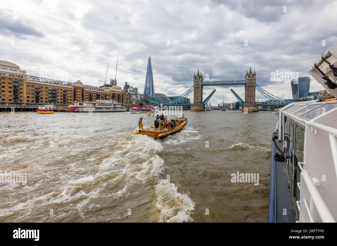 Ein Schnellboot auf der Themse fährt in Richtung der offenen Tower Bridge in Docklands, Pool of London bei Butlers Wharf, Bermondsey Stockfoto