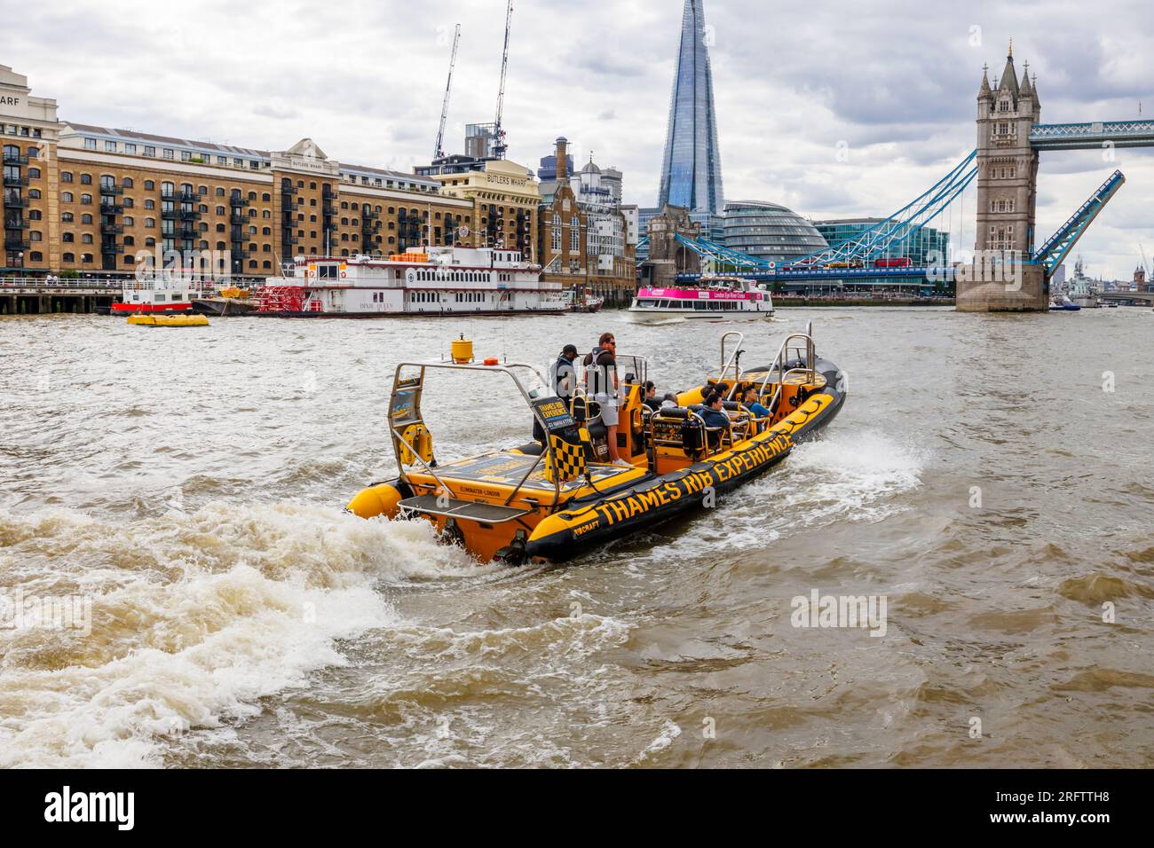 Ein Schnellboot auf der Themse fährt in Richtung der offenen Tower Bridge in Docklands, Pool of London bei Butlers Wharf, Bermondsey Stockfoto