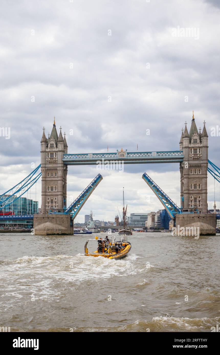 Ein Schnellboot auf der Themse fährt in Richtung der offenen Tower Bridge in Docklands, Pool of London bei Butlers Wharf, Bermondsey Stockfoto