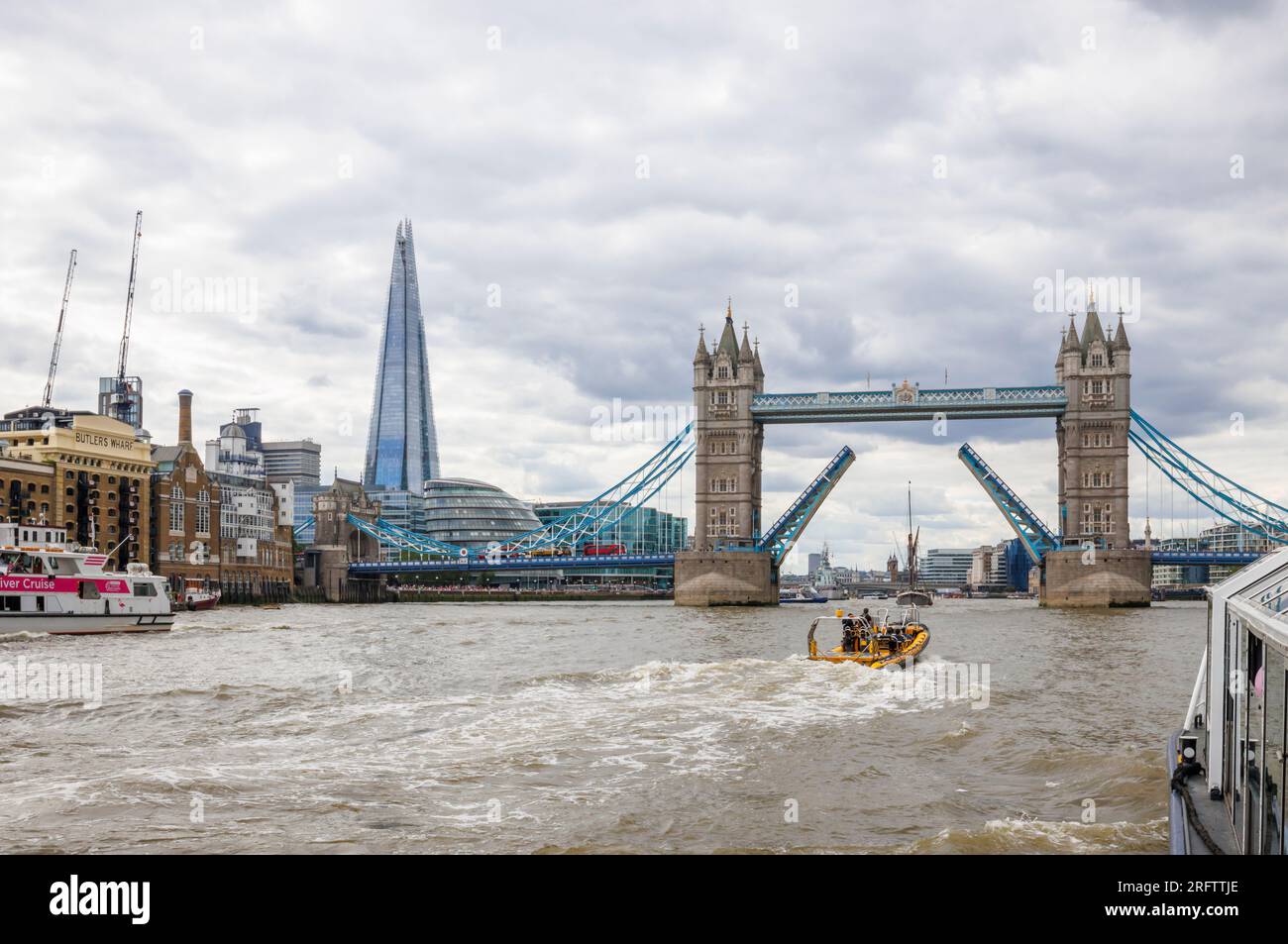 Ein Schnellboot auf der Themse fährt in Richtung der offenen Tower Bridge in Docklands, Pool of London bei Butlers Wharf, Bermondsey Stockfoto