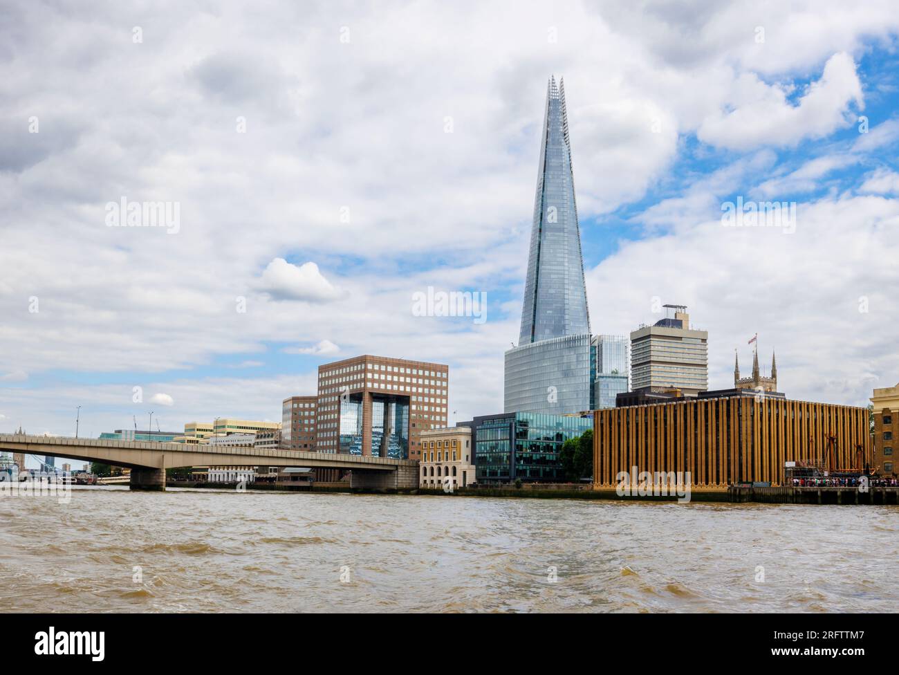 Der berühmte moderne Shard Wolkenkratzer in Southwark SE1 und die London Bridge, die von der Themse in London aus vor einem wolkigen Himmel zu sehen sind Stockfoto