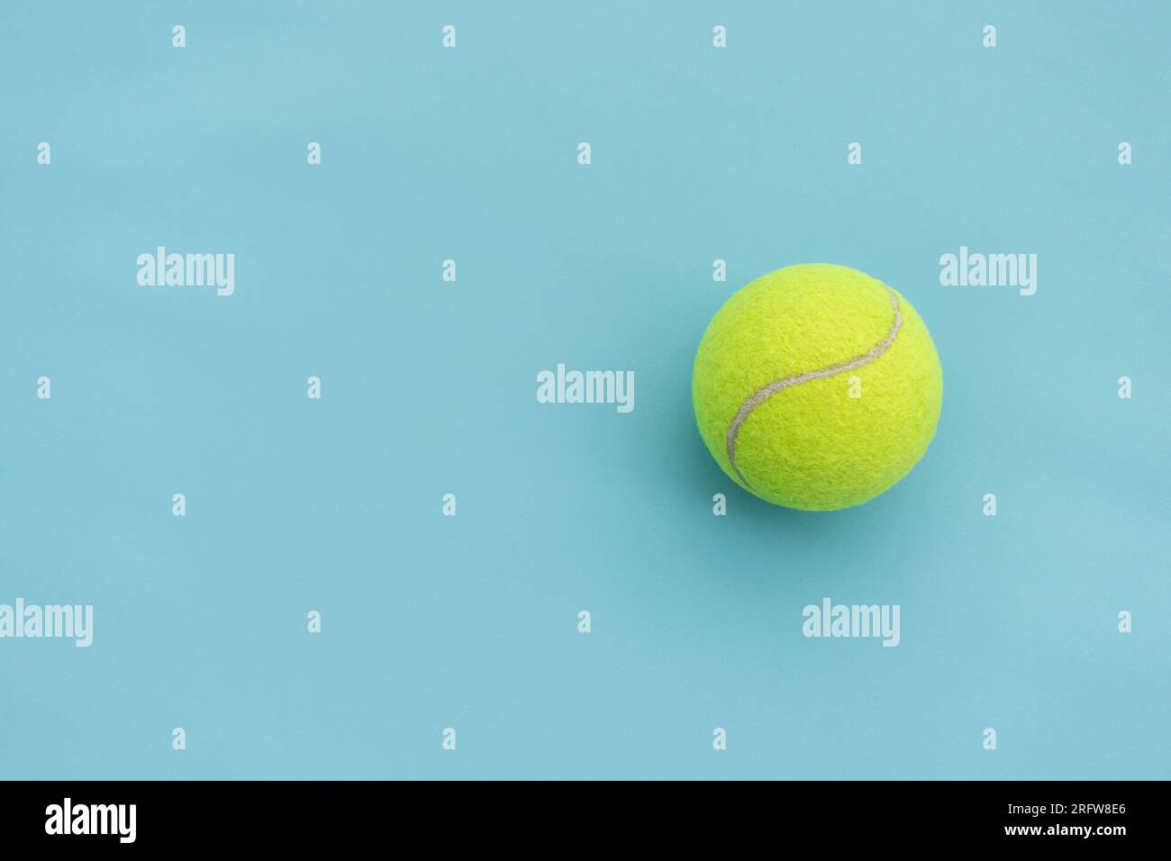 Ein Tennisball isoliert auf blauem Hintergrund, nach einigen Änderungen. Stockfoto