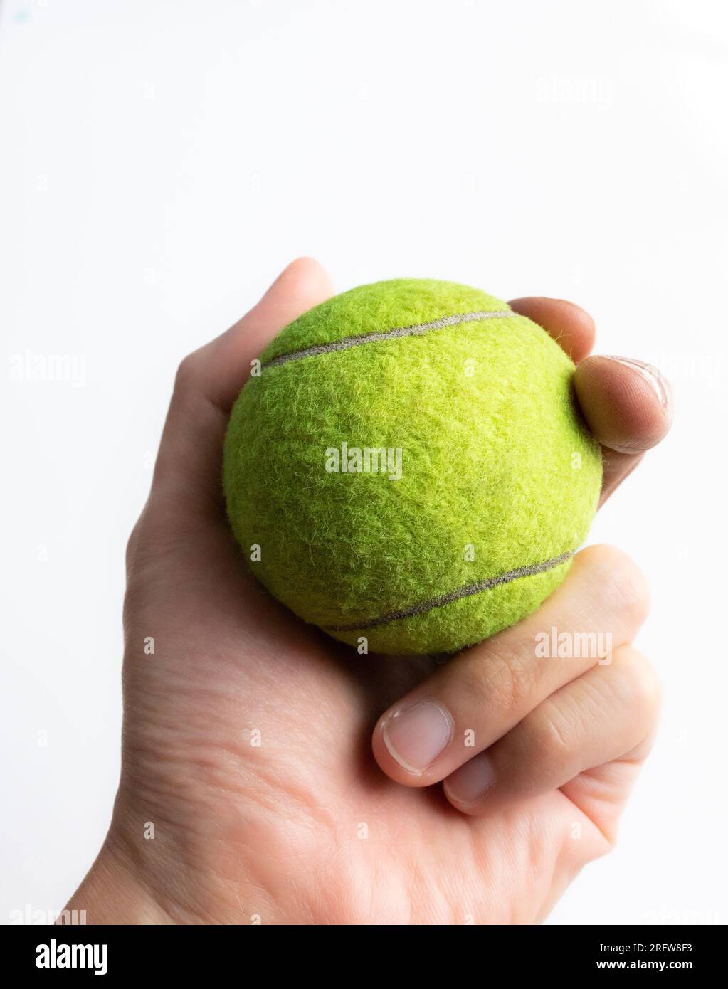 Hand hält einen Tennisball, nach einigen Änderungen. Stockfoto