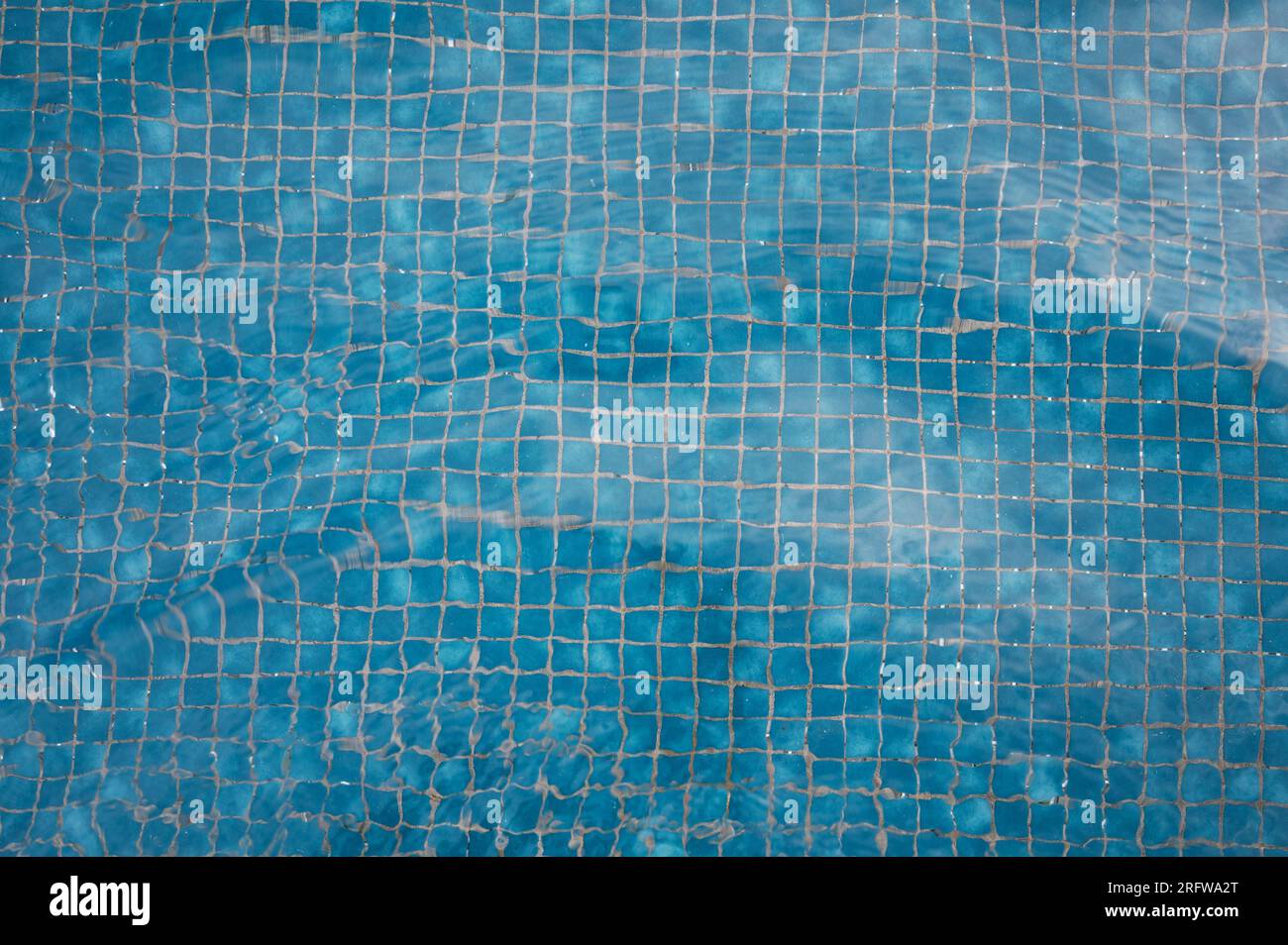 Blaue Poolfliesen verzerrt mit Wasserwellen Hintergrund Nahaufnahme Stockfoto