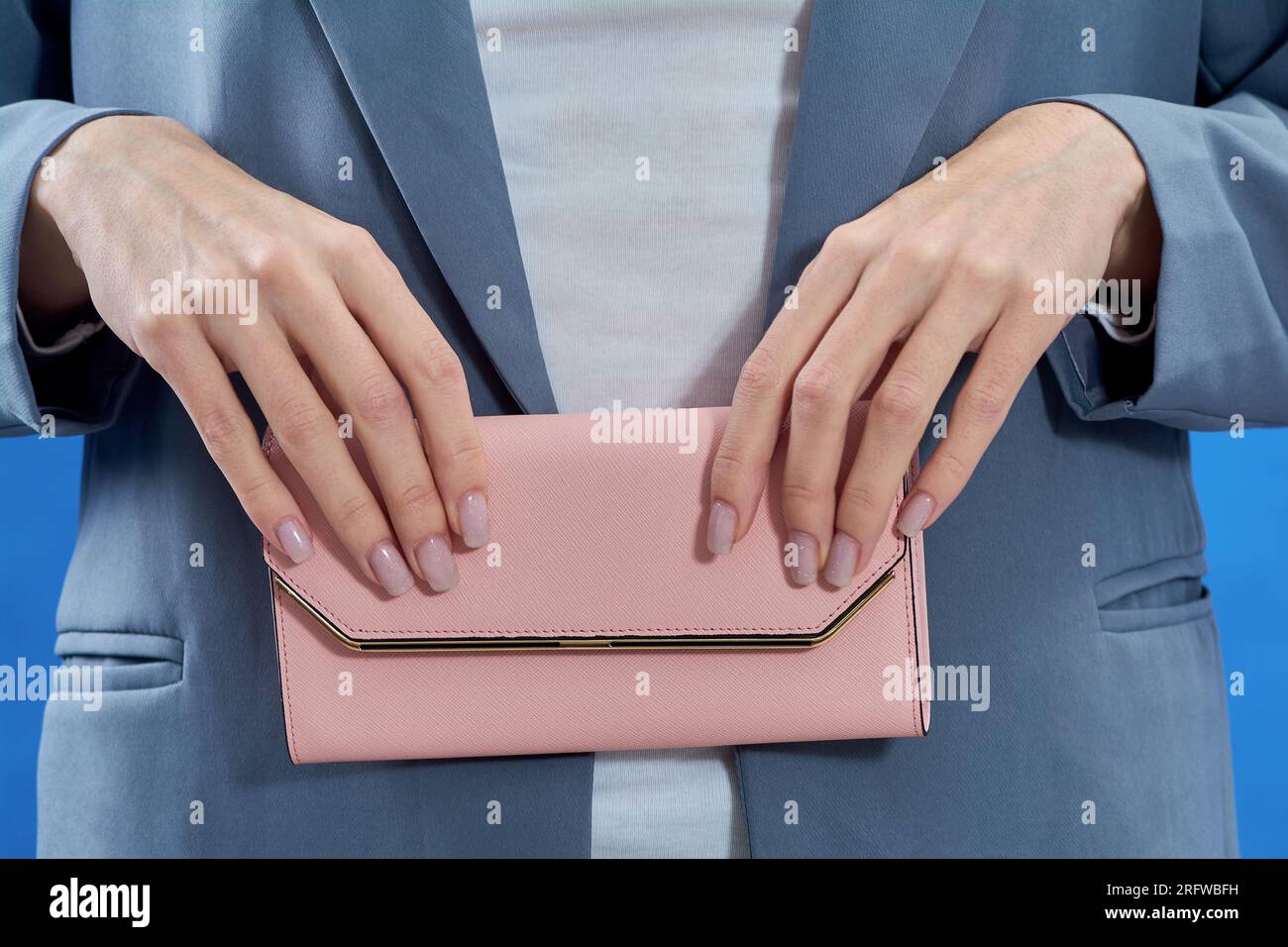 Frauenhände halten eine rosa Handtasche Stockfoto