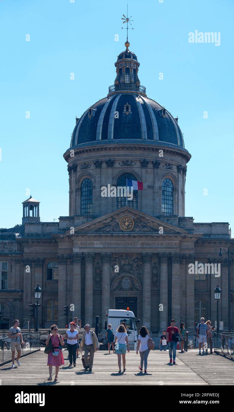 Paris, Frankreich - Juli 17 2017: Menschen überqueren die seine auf der Pont des Arts, gegenüber dem Institut de France. Stockfoto