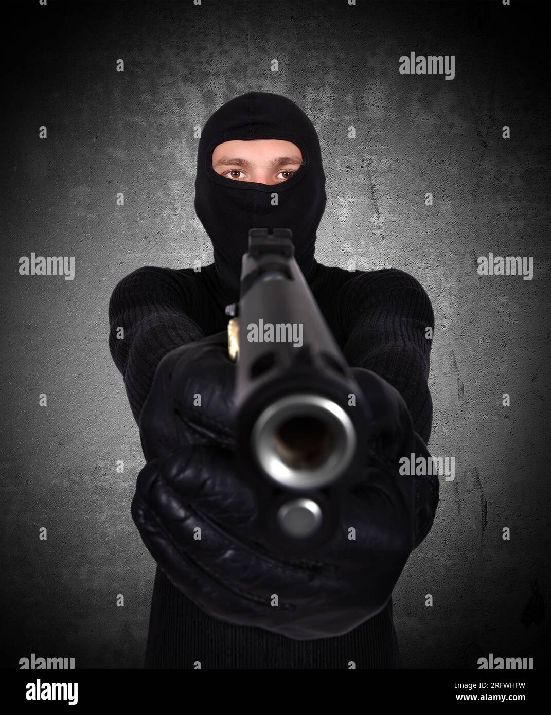 Terrorist mit Pistole auf schwarze Wand Hintergrund Stockfoto