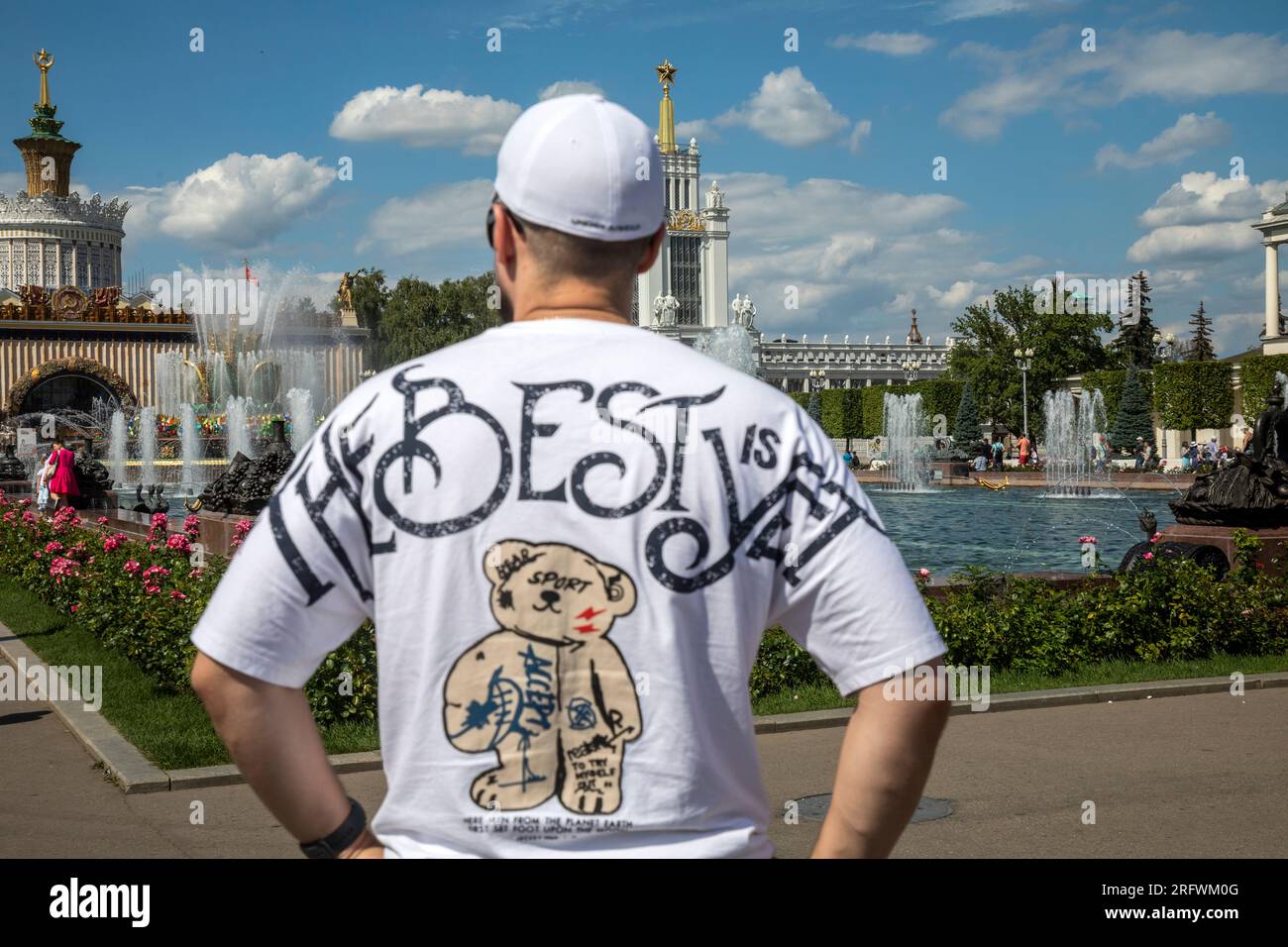 Moskau, Russland. August 2023. Ein Mann schaut an einem heißen Sommertag in Russland auf den Steinblumenbrunnen auf dem Territorium des VDNH-Ausstellungskomplexes in Moskau Stockfoto