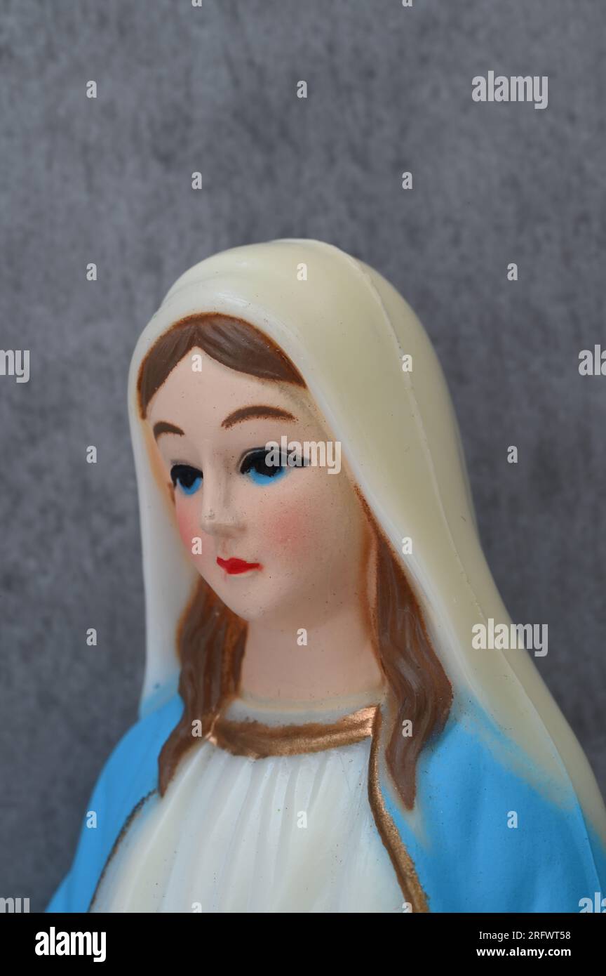 Modell der Jungfrau Maria mit großen blauen Augen, die traurig aussehen und blauen Bademantel tragen Stockfoto