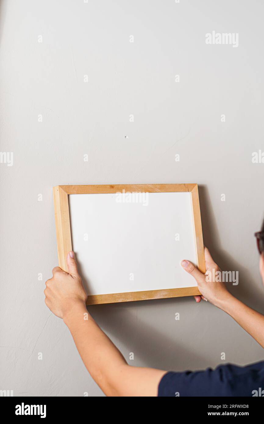 Modell für Ihre Konstruktion. Ein Holzrahmen mit leerem Platz in Frauenhänden Stockfoto