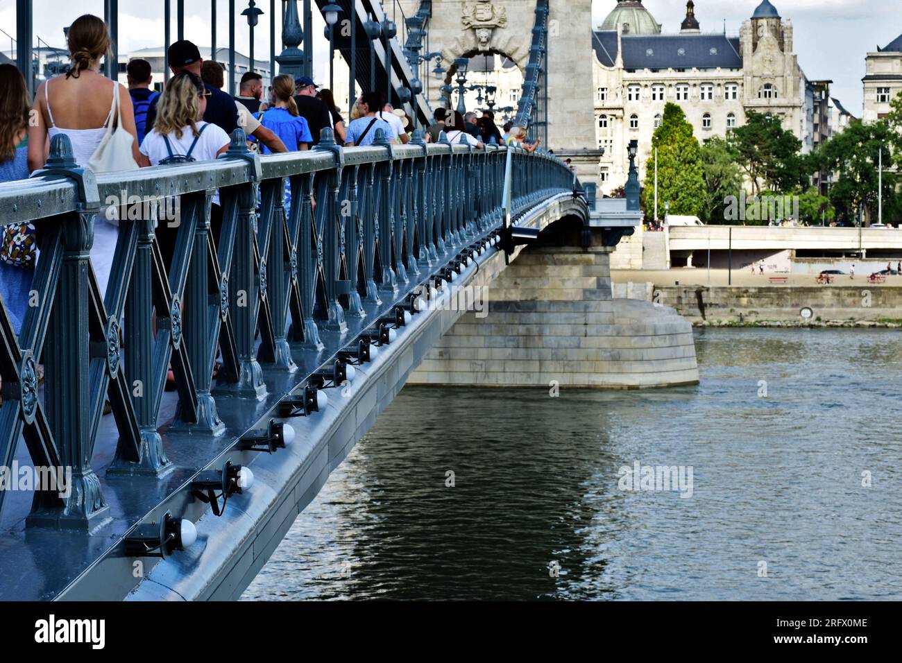 Ausblick auf die renovierte Kettenbrücke. Tourboot auf der Donau. Die Pest-Seite im Hintergrund. Sie wieder für die Öffentlichkeit zugänglich machen, Leute laufen. Stockfoto
