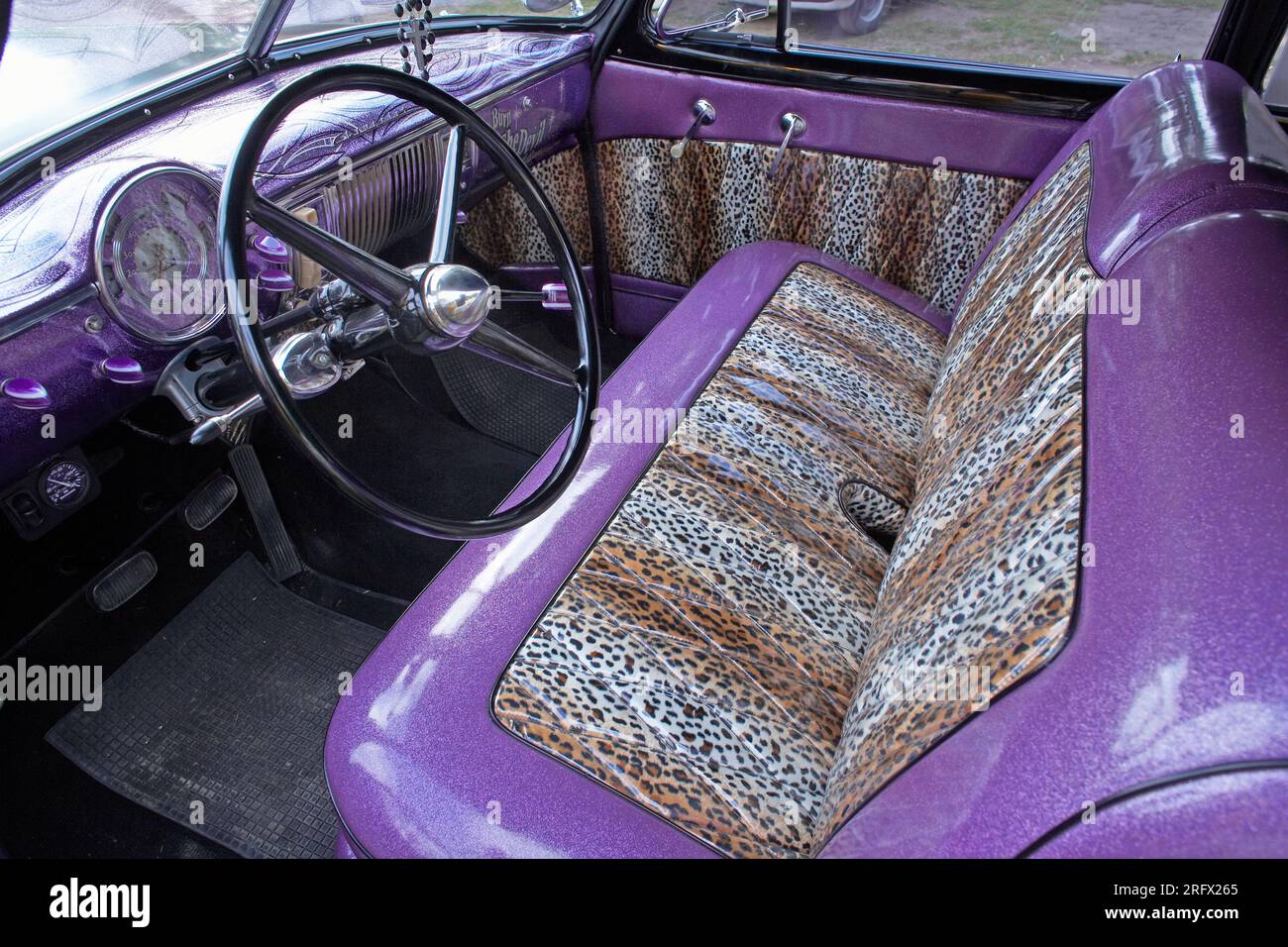 Klassischer amerikanischer Fahrzeuginnenraum mit Sitzen in Leopardenhaut. Sitzbezug im Auto mit Leopardenmuster Stockfoto